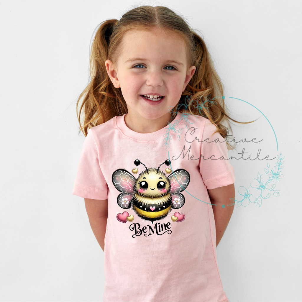 Girl wearing a pink Be Mine Bee shirt