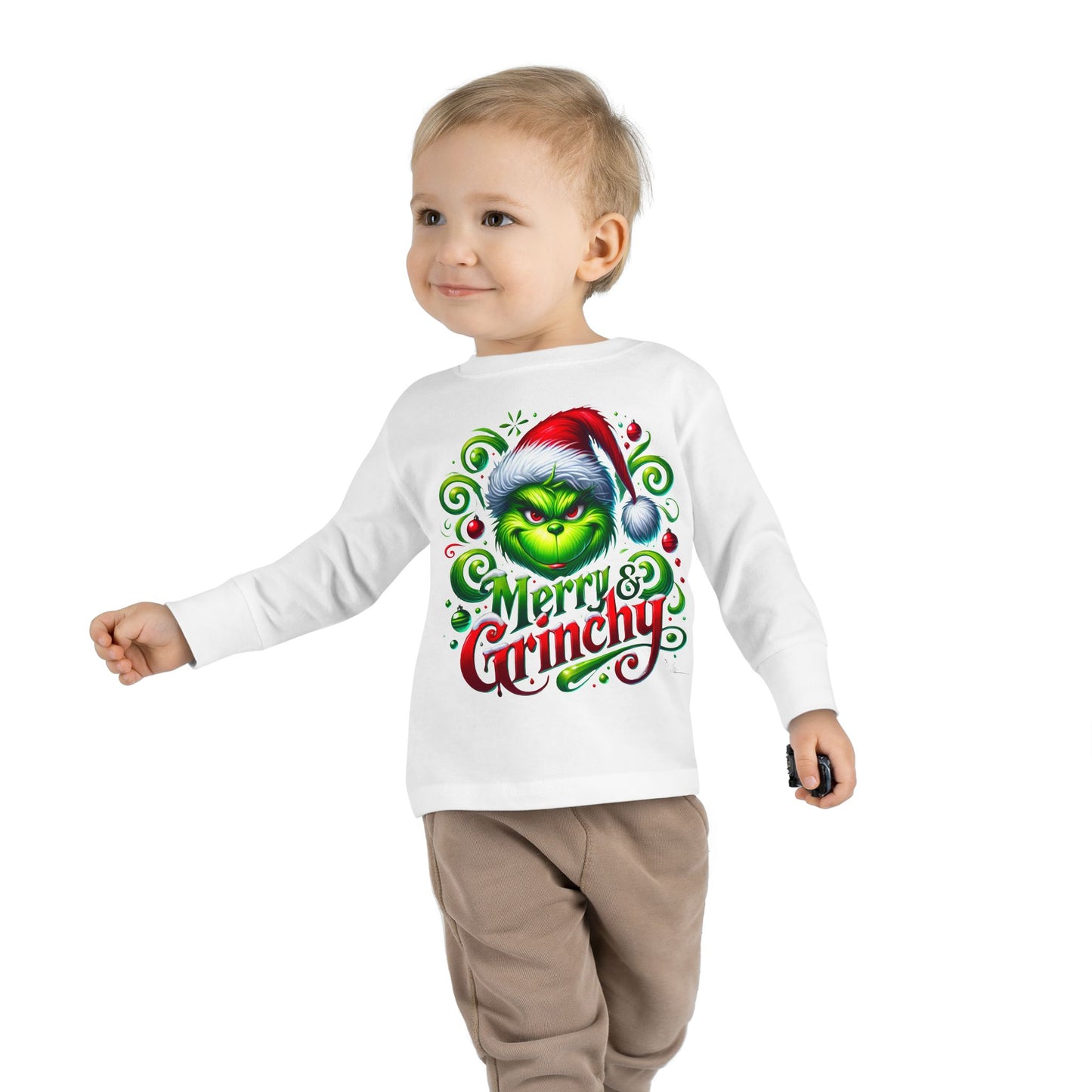 A toddler wearing a Merry Christmas Grinchy graphic tee